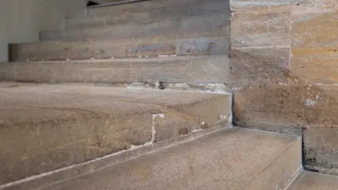 National Trust/James Beck Grey ham stone stairs leading to the top of the image. Some of the joines have been filled, with visible erosion on the steps.