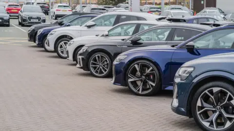 A row of Audi cars in a dealership lot
