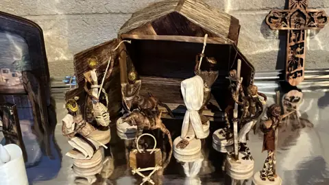 An African nativity scene, with figures made from grasses and a stable at the back, also made from natural materials.