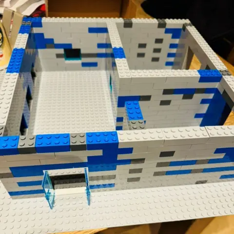 Mike Duxbury Blue and grey Lego blocks which have been used to create a building design.