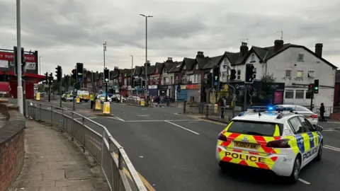 A police car parked at the junction of two road 