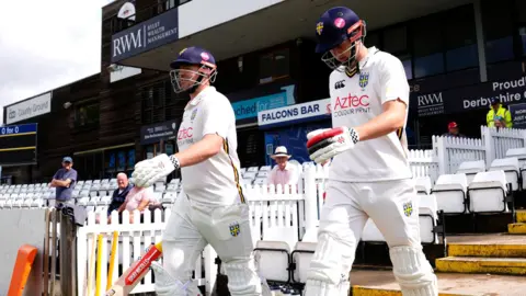 Durham openers Alex Lees (left) and Ben McKinney walking out to bat in their cricketing whites at Derby 