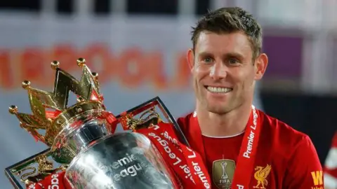 James Milner with the Premier League trophy after Liverpool's title win in 2020
