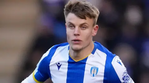 Will Goodwin wearing a Colchester United shirt