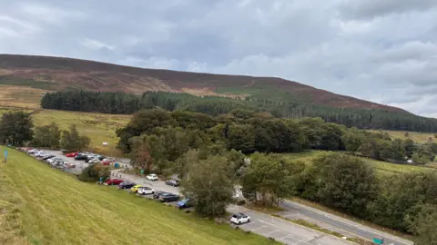 Local Democracy Reporting Service An aerial view of a country car park surrounded by greenery and trees