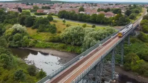 Northern An aerial view of a train running across a viaduct