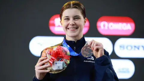 Andrea Spendolini-Sirieix holds up her bronze medal