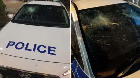 A collage of two images. The left image is a white police car with a smashed windscreen. "police" is written on the bonnet in blue capital letters. The image on the right is a close up of a smashed windscreen.