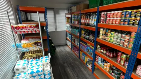 City of Wolverhampton Council Rows of food items and kitchen rolls are seen on shelves inside the mobile unit.