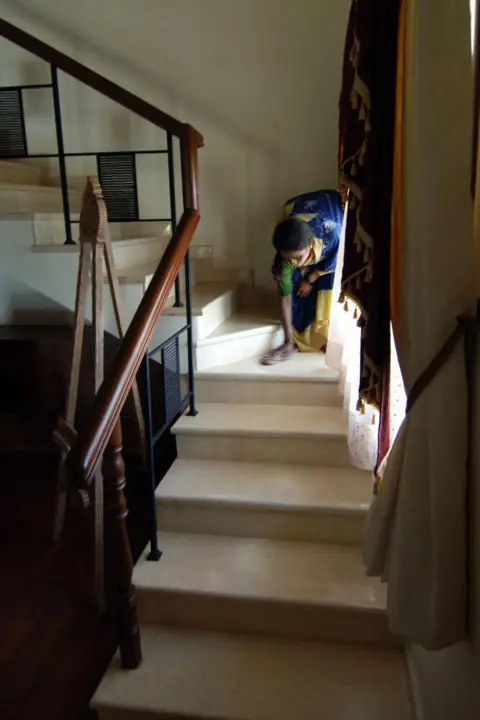 AFP via Getty Images  An Indian worker of the construction firm Alliance Infrastructure Projects Limited cleans a stairway in a show house at a new housing development in Bangalore
