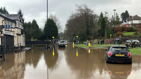 Photograph of cars in floodwater at the Bramhall roundabout in Stockport.