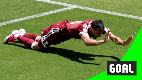 Qatar's Boualem Khoukhi celebrates equalising in extra time against Switzerland in the 2026 World Cup.