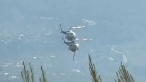 A screenshot showing two helicopters in Greece battling wildfires just moments before the mid-air collision. Photo: 2 August 2026