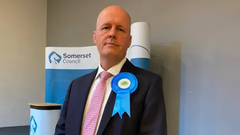 Conservative MP for Bridgwater Ashley Fox. He is standing in front of a podium.