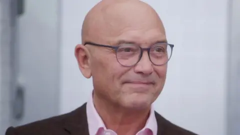 BBC/Shine TV A close up of Gregg Wallace, he's wearing glasses and smiling.