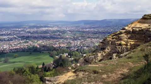 Getty Images A rock formation with many homes in the background of a wife landscape