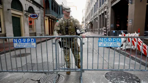 A member of the National Guard Military Police stands, in the area where people were killed by a man driving a truck in an attack during New Year's celebrations, in New Orleans