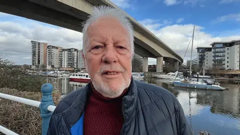 BBC Peter Larwood standing in the shadow of Cardiff's Victoria Wharf development