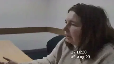 Erin Patterson sitting at a table being questioned by Australian police.