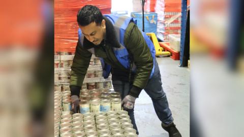 Abdulla Almamun stacking canned food