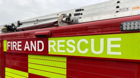 The side of a fire engine, with "Fire and Rescue" in bold letters on the side.