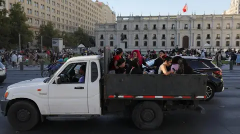 Reuters ride on the back of a vehicle between a large power outage on February 25, 2025 in Santiago, Chile.