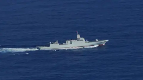 Força de Defesa Australiana Um navio chinês à distância navegando no mar de corais, a nordeste da Austrália, em 15 de fevereiro.