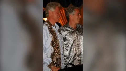 Bill Clinton and Jeffrey Epstein are pictured standing smiling side-by-side