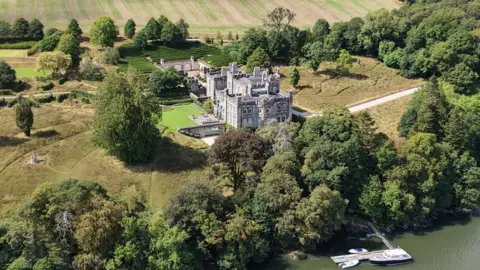Reuters An aerial view of a castle, surrounded by trees and fields. It is overlooking a river.