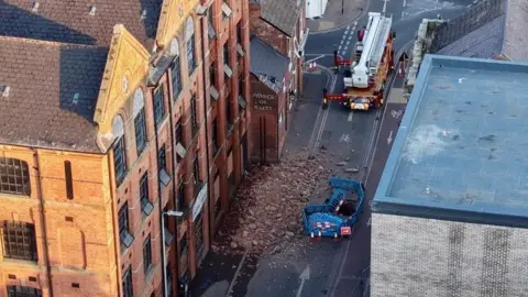 Leicester Media Online Aerial view of the collapse of a former factory building in Wharf Street South in Leicester city centre with fire engines in attendance.
