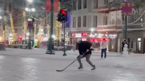 Man playing ice hockey on frozen street