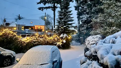 BBC Weather Watchers Snow sitting on a car and a hedge.