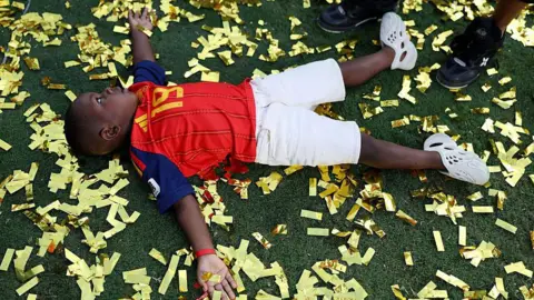 Maja Hitij - FIFA / Getty Images Kenye lies on the ground surrounded by golden confetti