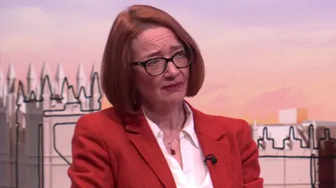 Dr Mary-Ann Stephenson looks to the side in the Laura K studio