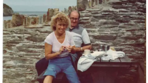 Noah Wild An old family photo of a couple pictured on a bench by the sea
