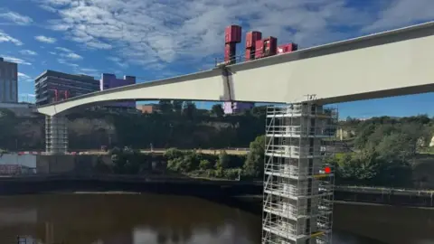 Photo shows the final, and largest, section of the new Wear footbridge having been lifted into place last September.
