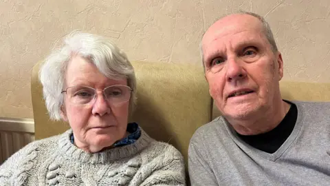 Jane Jones and her husband Peter both in grey jumpers