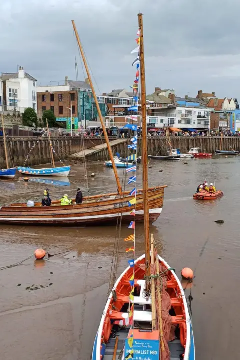 RNLI/Gail Spowage The Three Brothers wooden boat can be seen at low tide. All the boats around it are unable to move, apart from the lifeboat