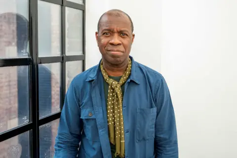 getty Clive Myrie pictured in blue shirt and polker dot scarf