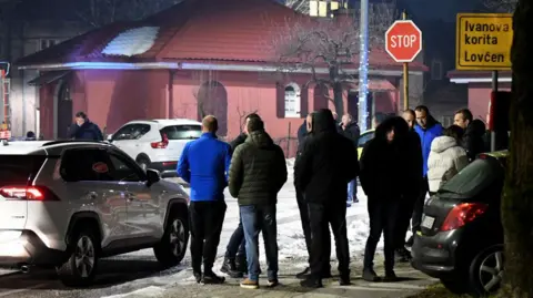 AFP Police officers and civil protection units secure a crime scene after a gunman killed several people in the village of Bajice near Cetinje, on January 1, 2025