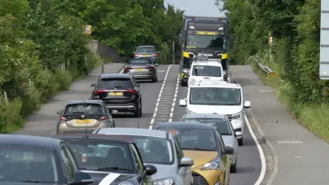 Richard Daniel/BBC A long line of cars queuing over a small bridge on the A120 at Marks Tey.