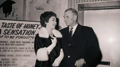 Getty Images Joan Plowright and Sir Laurence Olivier next to the poster for A Taste of Honey in 1961