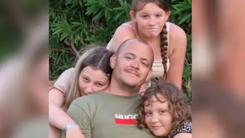 Adele Cook Man with his three children.