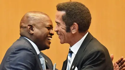 AFP Botswana's President Mokgweetsi Masisi is congratulated by outgoing President Ian Khama (R) in Gaborone - 1 April 2018