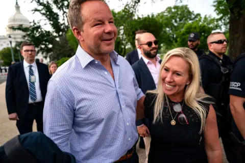 Getty Images Glen con el brazo alrededor de un Greene sonriente. El Capitolio de los Estados Unidos está en segundo plano