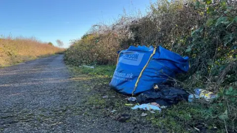 A bulk bag filled with rubbish, left on the side of Blenheim Lane.