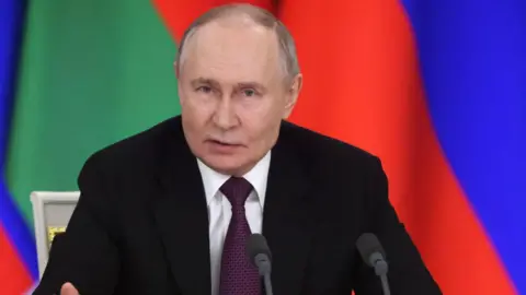 Vladimir Putin wears a dark black suit jacket with purple tie during Thursday's news conference