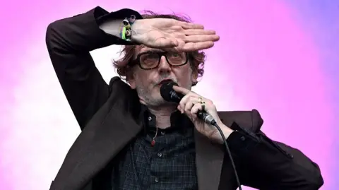 Jarvis Cocker poses on stage at Glastonbury