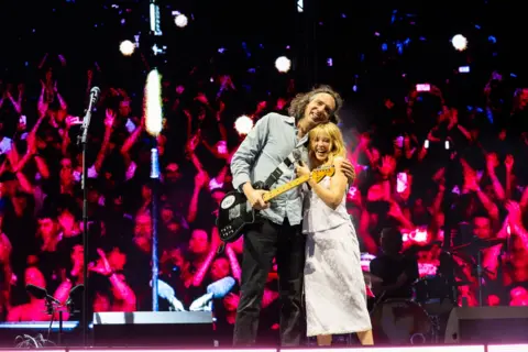 Bradley Quinn Kylie Minogue and Gary Lightbody hug on stage, after performing their song at Crystal Palace