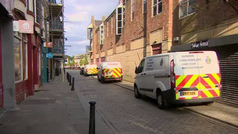 BBC Three Durham Constabulary vans parked along a street
